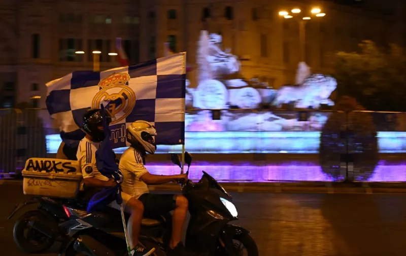 Real Madrid´s fans celebrate waving a flag on a bike at Cibeles square after Real Madrid won the Liga title on July 16, 2020 in Madrid. (Photo by GABRIEL BOUYS / AFP)