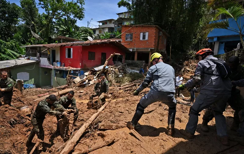 Rescue personnel work at a flood-affected area in Barra do Sahy, Sao Sebastiao district, Sao Paulo state, Brazil on February 21, 2023. - Lifeguards continued to search for survivors on the Sao Paulo coast, where the heaviest rains in Brazil's history left at least 44 dead and dozens missing over the weekend, authorities said Tuesday. (Photo by NELSON ALMEIDA / AFP)