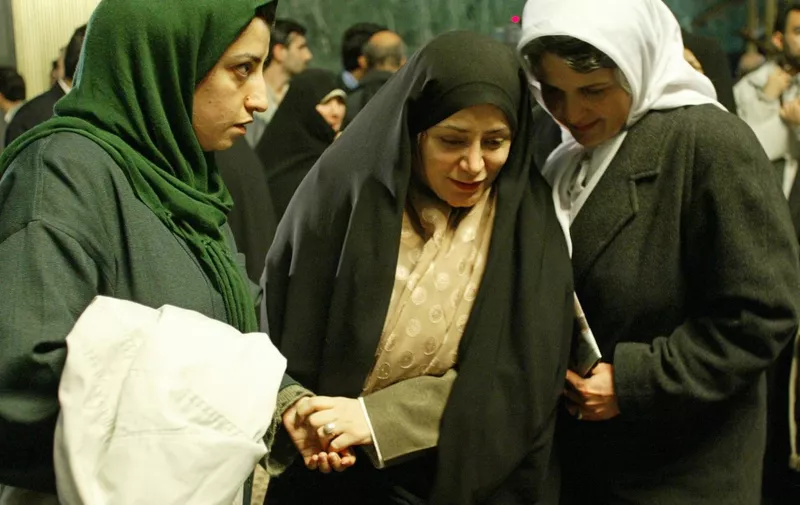 Iranian disqualified reformist MP, Fatimah Haqiqatjoo (C), speaks to Marziyeh Langeroudi (R), wife of political prisoner Habibollah Payman, as Narges Mohamadi (L), wife of political prisoner Taghi Rahmani, looks on during a sit-in at the parliament 13 January 2004 in Tehran. Disgruntled reformist MPs, 83 of whom have been barred from standing for re-election, kept up their sit-in at the Iranian parliament, or Majlis, for the third day and said they were willing to stay put for weeks, unless their rivals backed down on a move to bar reformers from next month's elections. AFP PHOTO/Henghameh FAHIMI (Photo by HENGHAMEH FAHIMI / AFP)