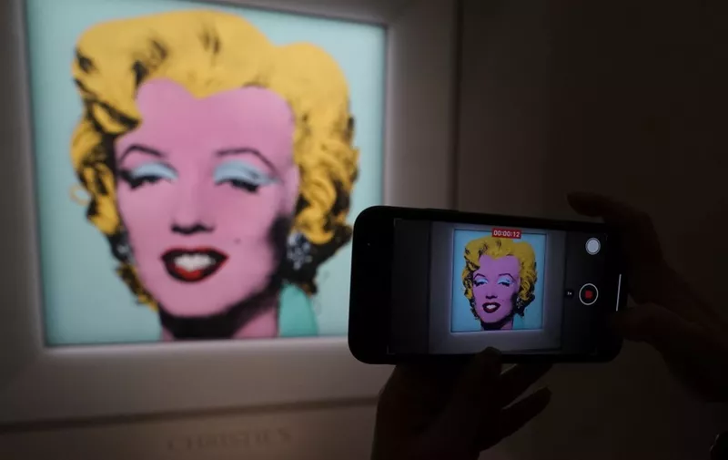 A journalist takes photos of Andy Warhols 1964 Shot Sage Blue Marilyn.during a press preview March 21, 2022 in New York. The iconic Andy Warhol silk-screen portrait of Hollywood starlet Marilyn Monroe is headed to Christies in New York later this spring for $200 milliona record asking price for any artwork at auction. (Photo by TIMOTHY A. CLARY / AFP)