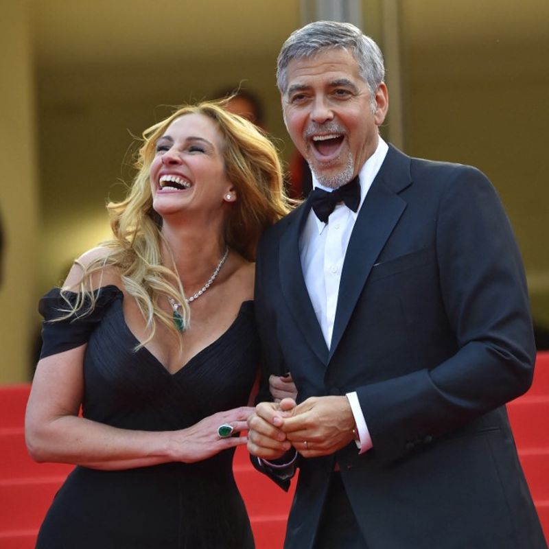 US actress Julia Roberts laughs on May 12, 2016 with US actor George Clooney as they arrive for the screening of the film "Money Monster" at the 69th Cannes Film Festival in Cannes, southern France. (Photo by LOIC VENANCE / AFP)