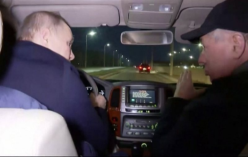 In this grab taken from video released by Russian broadcaster VGTRK as POOL on March 19, 2023, shows Russia's Vladimir Putin (L) driving with Deputy Prime Minister Marat Khusnullin as he visits the Ukranian city of Mariupol late March 18, 2023. - Russian President Vladimir Putin made a surprise trip to Mariupol, the Kremlin said, his first visit to territory captured from Ukraine since the start of Moscow's offensive. Just hours after Putin visited Crimea to mark the ninth anniversary of the peninsula's annexation, video distributed by the Kremlin showed him landing by helicopter in Mariupol, the port city that Moscow captured after a long siege last spring. (Photo by various sources / AFP)