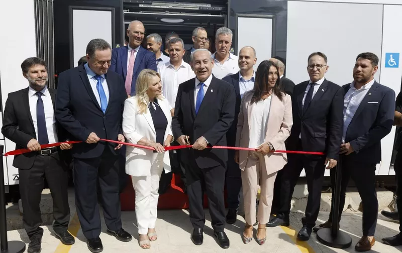 Israel's Prime Minister Benjamin Netanyahu (C), flanked by his wife Sara (C-L), Transportation Minister Miri Regev (C-R), Finance Minister Bezalel Smotrich (L) and Energy Minister Israel Katz (2nd-L), attends the inauguration of the new light rail line for the Tel Aviv metropolitan area, in Petah Tikva, on August 17, 2023. (Photo by AMIR COHEN / POOL / AFP)