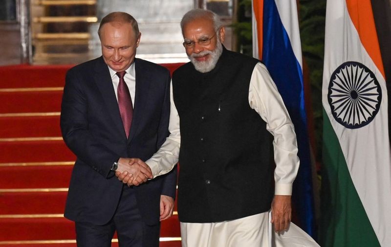 India's Prime Minister Narendra Modi (R) greets Russian President Vladimir Putin before a meeting at Hyderabad House in New Delhi on December 6, 2021. (Photo by Money SHARMA / AFP)