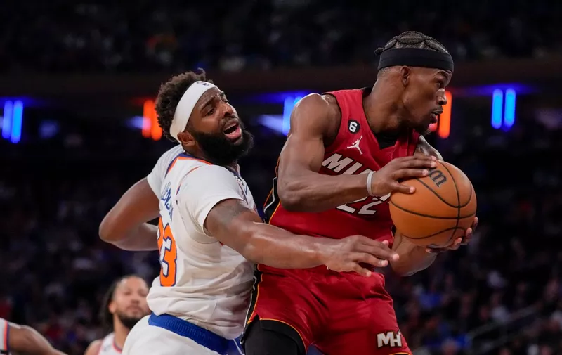 Miami Heat forward Jimmy Butler (22) rebounds against New York Knicks center Mitchell Robinson (23) during the first half of Game 1 in the NBA basketball Eastern Conference semifinals playoff series, Sunday, April 30, 2023, in New York. (AP Photo/John Minchillo)