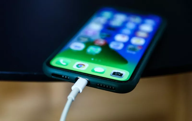Apple iPhone connected to a Lightning cable is seen in this illustration photo taken in Poland on September 25, 2021. (Photo by Jakub Porzycki/NurPhoto) (Photo by Jakub Porzycki / NurPhoto / NurPhoto via AFP)