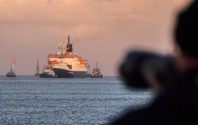 A man takes a picture of German icebreaker and research vessel "Polarstern" upon arrival at the harbour of nothern German town of Bremerhaven, on October 12, 2020, after a year-long mission, the biggest Arctic expedition in history, bringing home observations from scientists that sea ice is melting at a "dramatic rate" in the region. The researchers' observations have been backed up by US satellite images showing that in 2020, sea ice in the Arctic reached its second-lowest summer minimum on record, after 2012. The Polarstern mission, dubbed MOSAIC, spent 389 days collecting data on the atmosphere, ocean, sea ice and ecosystems to help assess the impact of climate change on the region and the world. (Photo by Patrik Stollarz / AFP)