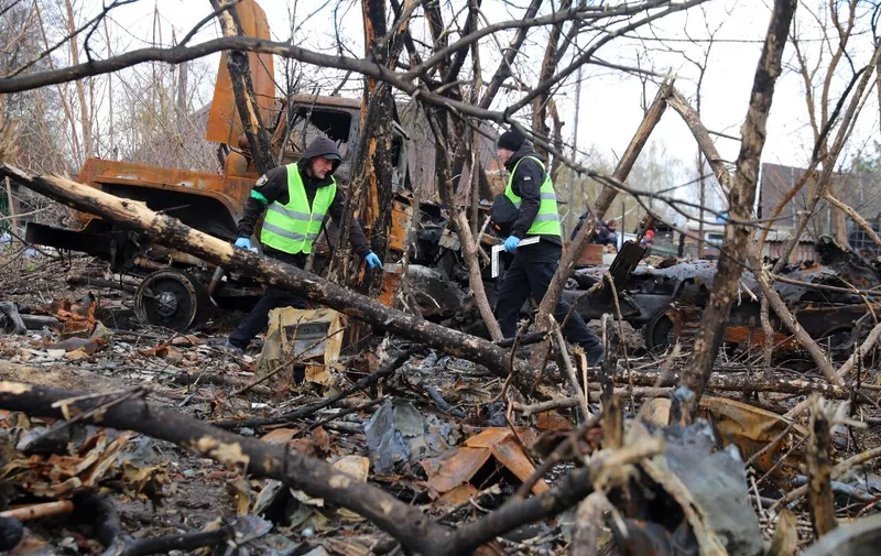 Ukrainian police forensic investigators examine an area with burnt Russian military vehicles destroyed during fighting, in the village of Bervytsia, near Brovary, northeast of Kyiv, on April 21, 2022, amid Russia's military invasion launched on Ukraine. (Photo by Aleksey Filippov / AFP)