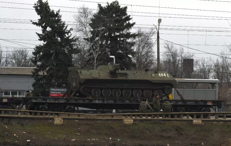 A Russian military vehicle is seen loaded on a train platform at the Neklinovka railway station in Russia's southern Rostov region, which borders the self-proclaimed Donetsk People's Republic, on February 23, 2022. (Photo by STRINGER / AFP)