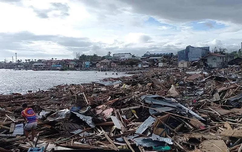 In this photo taken on December 17, 2021, residents trie to salvage belongings next to destroyed houses along the coast in Ubay town, Bohol province, in central Philippines, a day after super Typhoon Rai devastated the town. (Photo by Dave Responte / AFP)