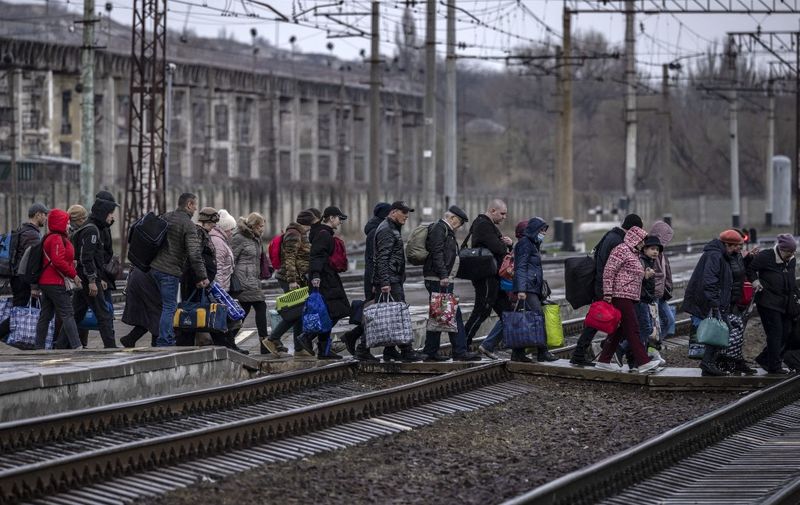 Families arrive at the main train station as they flee the eastern city of Kramatorsk, in the Donbas region on April 3, 2022. - AFP journalists saw women, children and elderly people boarding a train at the station to flee the eastern city of Kramatorsk in the Donbas region as Moscow refocuses its offencive on southern and eastern Ukraine. "The rumour is that something terrible is coming," said Svetlana, a volunteer organising the crowd on the station platform. Russia invaded Ukraine on February 24, 2022. (Photo by FADEL SENNA / AFP)