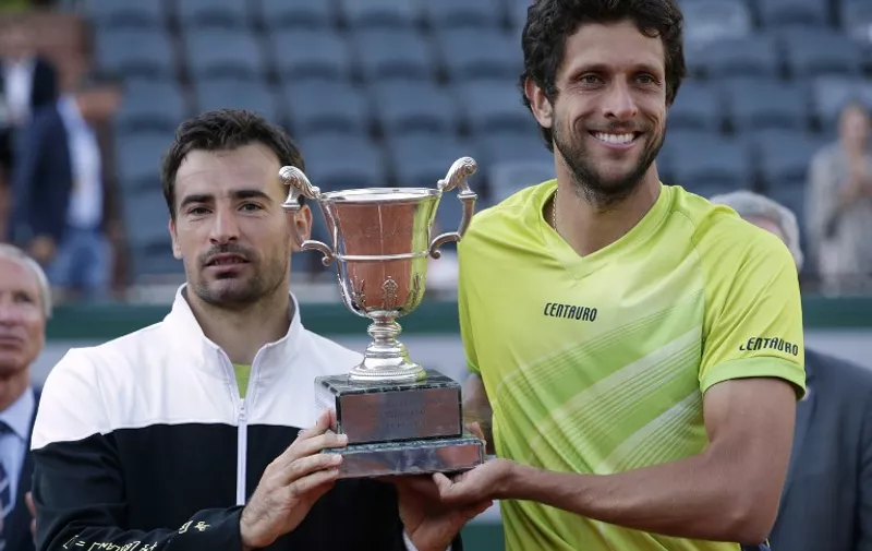 Brazil's Marcelo Melo (R) and Croatia's Ivan Dodig celebrate with the trophy following their victory over US Bob and Mike Bryan celebrate at the end of the men's double final match of the Roland Garros 2015 French Tennis Open in Paris on June 6, 2015.    AFP PHOTO / KENZO TRIBOUILLARD