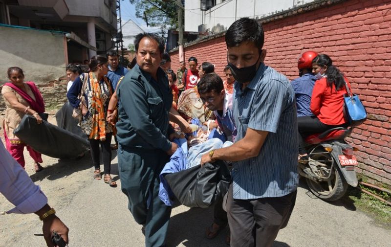 TOPSHOTS
Nepalese patients are carried out of a hospital building as a 7.4 magnitude earthquake hits the country, in Kathmandu on May 12, 2015.   A 7.4-magnitude earthquake hit devastated Nepal, sending terrified residents running into the streets in the capital Kathmandu, according to witnesses and the US Geological Survey.  The quake struck at 12:35pm local time in the Himalayan nation some 83 kilometres (52 miles) east of Kathmandu, more than two weeks after a 7.8-magnitude quake which killed more than 8,000 people.   AFP PHOTO / PRAKASH MATHEMA