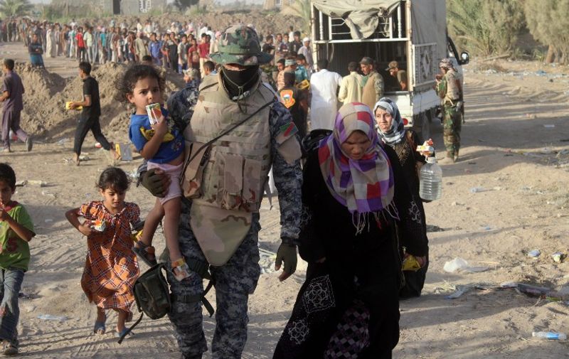 A displaced Iraqi family arrives at a safe zone on June 17, 2016 in Amriyat al-Fallujah, after Iraqi government forces evacuated civilians from the city of Fallujah due to their ongoing military operation to retake the city from the Islamic State (IS) group.
Iraqi forces raised the national flag over the government compound in Fallujah on June 17, 2016, top commanders said, a breakthrough in the nearly four-week-old offensive against the Islamic State group's bastion. Significant parts of northern Fallujah, where thousands of civilians are believed to remain, have yet to be retaken. Amriyat al-Fallujah is located some 30 kilometers (18.6 miles) south of Fallujah.  / AFP PHOTO / MOADH AL-DULAIMI