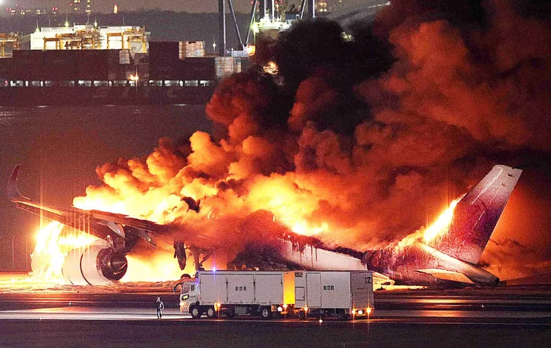 This photo provided by Jiji Press shows a Japan Airlines plane on fire on a runway of Tokyo's Haneda Airport on January 2, 2024. A Japan Airlines plane was in flames on the runway of Tokyo's Haneda Airport on January 2 after apparently colliding with a coast guard aircraft, media reports said. (Photo by JIJI PRESS / AFP) / Japan OUT