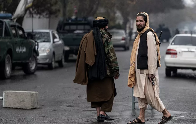 Members of the Taliban security forces walk near a site of an attack at Shahr-e-naw which is city's one of main commercial areas in Kabul on December 12, 2022. - A loud blast and gunfire were heard in the Afghan capital December 12 near a guest house popular with Chinese business visitors, a witness said. (Photo by Wakil KOHSAR / AFP)