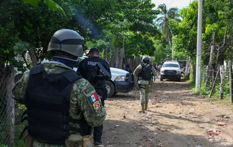 Security forces inspect the area where at least 11 police officers were killed in an ambush by criminal groups in Coyuca de Benitez, state of Guerrero, Mexico, on October 23, 2023. An armed attack left at least 11 police officers dead on Monday in a region of Mexico plagued by violence related to drug trafficking, authorities said. Unidentified attackers targeted a security patrol in the municipality of Coyuca de Benitez in the southern state of Guerrero, prosecutor Alejandro Hernandez said. (Photo by FRANCISCO ROBLES / AFP)