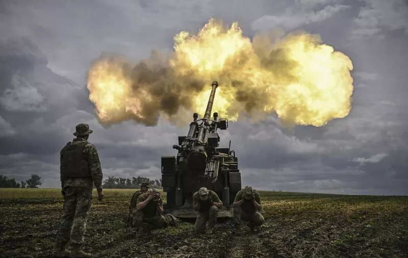 Ukrainian servicemen fire with a French self-propelled 155 mm/52-calibre gun Caesar towards Russian positions at a front line in the eastern Ukrainian region of Donbas on June 15, 2022. - Ukraine pleaded with Western governments on June 15, 2022 to decide quickly on sending heavy weapons to shore up its faltering defences, as Russia said it would evacuate civilians from a frontline chemical plant. (Photo by ARIS MESSINIS / AFP)