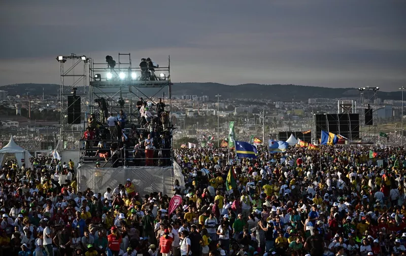 Pilgrims gather before the World Youth Days vigil with young people in Tejo Park, Lisbon, on August 5, 2023. Around one million pilgrims from all over the world will attend the World Youth Day, the largest Catholic gathering in the world, created in 1986 by John Paul II. (Photo by Marco BERTORELLO / AFP)