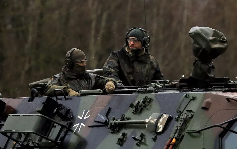 Soldiers of the German armed forces Bundeswehr arrive in an armoured vehicle at the NATO enhanced Forward Presence Battle Group Battalion in Lithuania in Rukla, Lithuania on February 17, 2022. (Photo by PETRAS MALUKAS / AFP)