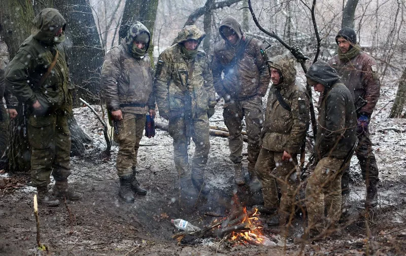Servicemen of Ukrainian Military Forces set a fire to get warm in the Luhansk region on March 3, 2022. (Photo by Anatolii Stepanov / AFP)