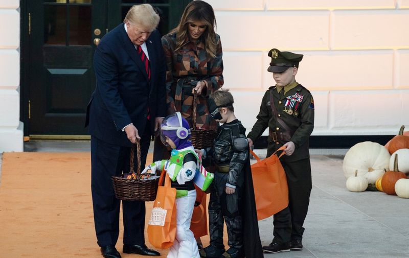 US President and First Lady Melania Trump hand out candy for children at a Haloween celebration at the White House in Washington, DC, on October 28, 2019. (Photo by NICHOLAS KAMM / AFP)
