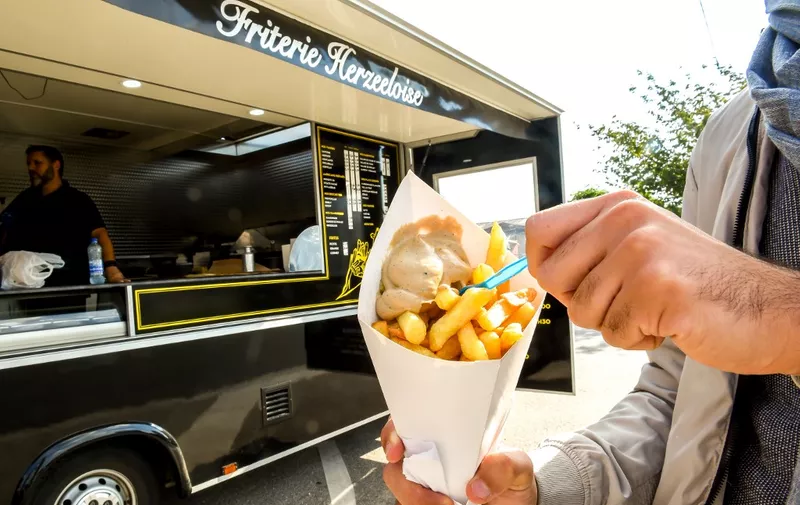 A customer buys French fries at a food truck in Steenvoorde, northern France on October 15, 2018 as the harvest of potatoes reduced following summer drought. (Photo by PHILIPPE HUGUEN / AFP)