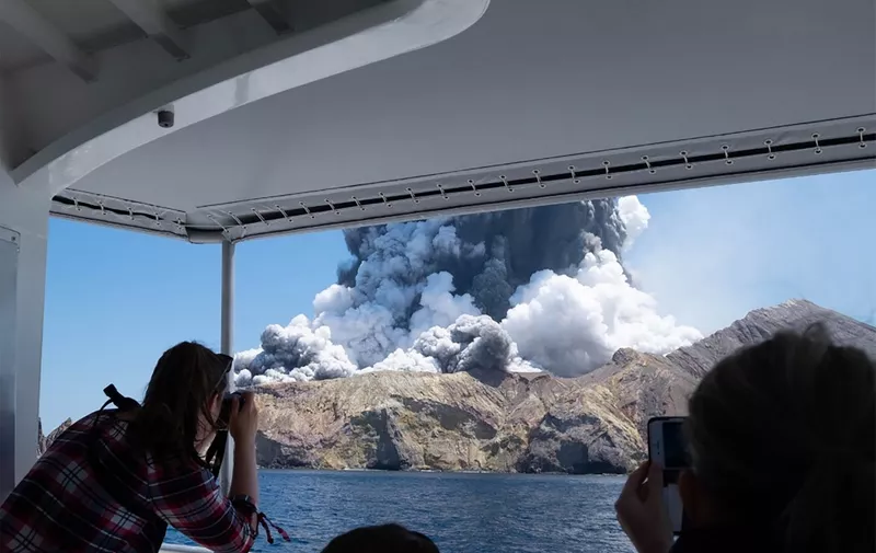 This handout photograph courtesy of Michael Schade shows the volcano on New Zealand's White Island spewing steam and ash moments after it erupted on December 9, 2019. - New Zealand police said at least one person was killed and more fatalities were likely, after an island volcano popular with tourists erupted on December 9 leaving dozens stranded. (Photo by Handout / Michael Schade / AFP) / RESTRICTED TO EDITORIAL USE - MANDATORY CREDIT "AFP PHOTO / MICHAEL SCHADE" - NO MARKETING NO ADVERTISING CAMPAIGNS - DISTRIBUTED AS A SERVICE TO CLIENTS == NO ARCHIVE