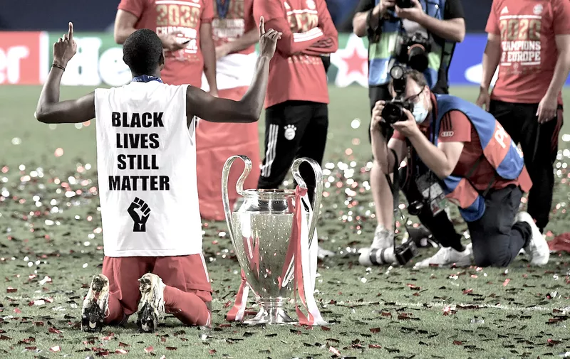 LISBON, PORTUGAL - AUGUST 23: The phrase 'Black Lives Still Matter' is seen on the back of David Alaba of FC Bayern Munich's shirt as he celebrates with the UEFA Champions League Trophy following his team's victory in the UEFA Champions League Final match between Paris Saint-Germain and Bayern Munich at Estadio do Sport Lisboa e Benfica on August 23, 2020 in Lisbon, Portugal. (Photo by David Ramos/Getty Images)