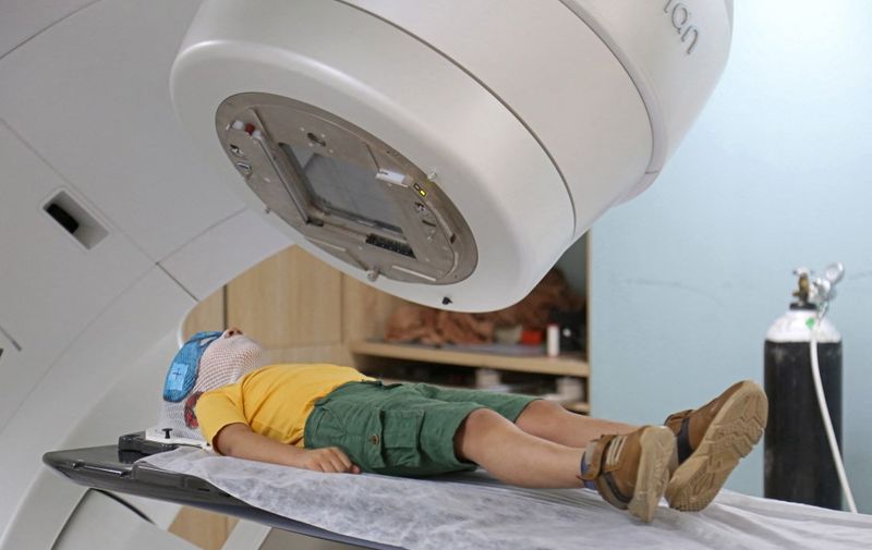 A boy undergoes radiotherapy at the Warith Oncology Hospital, which has initiated a 40-day free treatment campaign for cancer patients on the occasion of the Arbaeen religious festival, in Iraq's shrine city of Karbala on August 27, 2023. (Photo by Mohammed SAWAF / AFP)