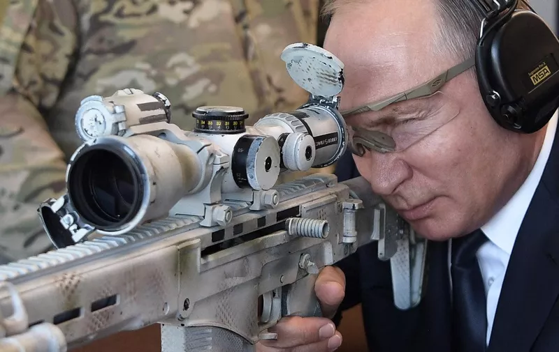 Russian President Vladimir Putin looks through the scope as he shoots a Chukavin sniper rifle (SVC-380) during a visit to the military Patriot Park in Kubinka, outside Moscow, on September 19, 2018. (Photo by Alexey NIKOLSKY / SPUTNIK / AFP)