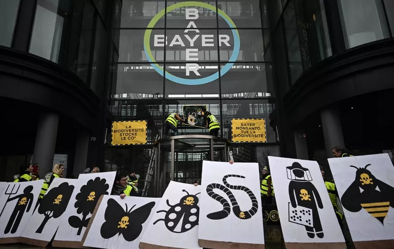 (FILES) In this file photo taken on March 14, 2019, activists stage a flash protest organised by the international movement Attac at the offices of Bayer - which recently acquired Monsanto - in La Garenne Colombes near the financial district of La Defense on the outskirts of Paris. - Germany's Bayer apologised on May 12, 2019 after revelations in France that its subsidiary Monsanto had a PR agency collate lists of politicians, scientists and journalists and their views on pesticides and GM crops. (Photo by Philippe LOPEZ / AFP)