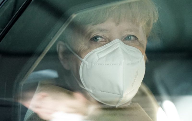 German Chancellor Angela Merkel wears a face mask as she sits in her car after holding a press conference on the Covid-19 situation in Germany at the house of the Federal Press Conference (Bundespressekonferenz), on January 21, 2021 in Berlin. (Photo by Michael Kappeler / POOL / AFP)