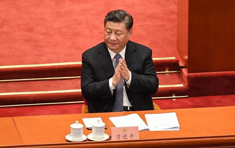 China's President Xi Jinping applauds during the opening ceremony of the Chinese People's Political Consultative Conference (CPPCC) at the Great Hall of the People in Beijing on March 4, 2022. (Photo by Matthew WALSH / AFP)