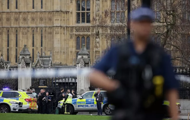 An armed British police officer stands on duty as members of the emergency services gather at the Carriage Gates entrance of the Houses of Parliament in Westminster, central London on March 22, 2017, during an emergency incident.
Three people were killed and 20 injured in a "terrorist" attack outside the British parliament Wednesday when a man mowed down pedestrians, then stabbed a police officer before being shot dead. The car struck pedestrians on Westminster Bridge, a popular spot with tourists because of its views of Big Ben, before crashing into the railings outside the heavily guarded parliament building in the heart of the British capital. / AFP PHOTO / DANIEL LEAL-OLIVAS