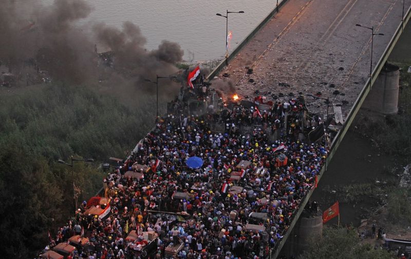 Iraqi protesters gather on al-Jumhuriya bridge which leads to the high-security Green Zone, during ongoing anti-government demonstrations in the capital Baghdad on October 31, 2019. - Iraq's president vowed today to hold early elections in response to a month of deadly protests, but demonstrators said the move fell far short of their demands for a political overhaul. (Photo by AHMAD AL-RUBAYE / AFP)