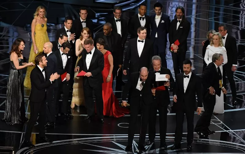 "La La Land" producer Jordan Horowitz (front C) shows the card saying "Moonlight" won the best picture as actor Warren Beatty  (front 4R), and Host Jimmy Kimmel (3R) look on at the 89th Oscars on February 26, 2017 in Hollywood, California. / AFP PHOTO / Mark RALSTON