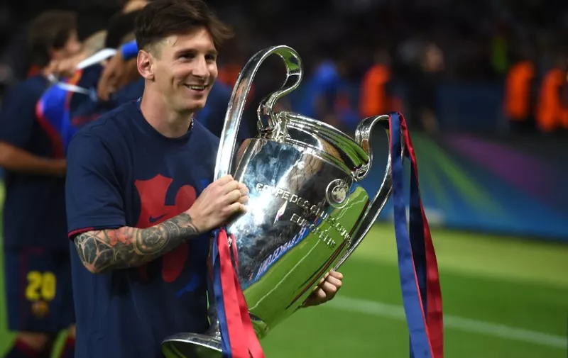 Barcelona's Argentinian forward Lionel Messi holds the trophy after the UEFA Champions League Final football match between Juventus and FC Barcelona at the Olympic Stadium in Berlin on June 6, 2015. FC Barcelona won the match 1-3.        AFP PHOTO / PATRIK STOLLARZ