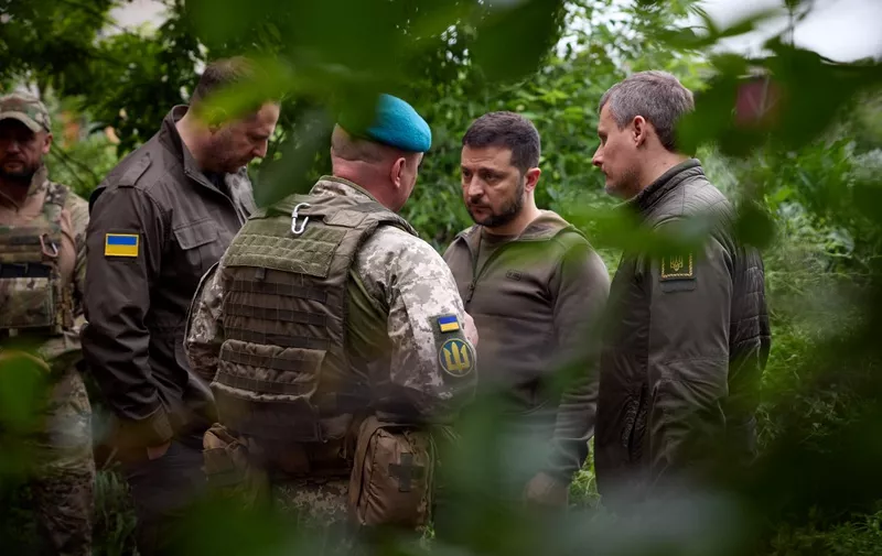 This handout photograph taken and released by Ukrainian Presidential press-service on May 23, 2023 shows the Ukrainian President Volodymyr Zelensky (CR) talking with officers during his visit to the forward positions of the Armed Forces of Ukraine in the Vugledar-Maryinka defense zone, Donetsk region, on the occasion of the Marine Day, amid the Russian invasion of Ukraine. (Photo by Handout / AFP)
