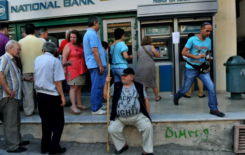 People queue at an ATM outside of a National bank branch in Thessaloniki on July 8, 2015. European leaders gave debt-stricken Athens a final deadline of Sunday to reach a new bailout deal and avoid crashing out of the euro, after Greek voters rejected international creditors' plans in a weekend referendum. Greek leaders must submit detailed reform plans by Thursday to win the fresh bailout funds the country needs to stop its banking system from collapsing, EU President Donald Tusk said after an emergency summit of Greek and eurozone leaders.  AFP PHOTO / SAKIS MITROLIDIS
