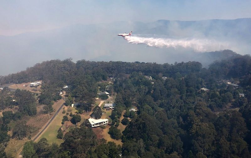This handout photo taken on September 8, 2019 and received on September 9 from the Queensland Fire and Emergency Services shows a firefighting 737 jet water bombing a fire at Binna Burra, some 100 kms (60 miles) south of Brisbane. - Australia battled to contain around 160 bushfires in the east of the country on September 9, an early start to a wildfire season that authorities warn could be the worst in decades. (Photo by Handout / QUEENSLAND FIRE AND EMERGENCY SERVICES / AFP) / -----EDITORS NOTE --- RESTRICTED TO EDITORIAL USE - MANDATORY CREDIT "AFP PHOTO / QUEENSLAND FIRE AND EMERGENCY SERVICES" - NO MARKETING - NO ADVERTISING CAMPAIGNS - DISTRIBUTED AS A SERVICE TO CLIENTS - NO ARCHIVES