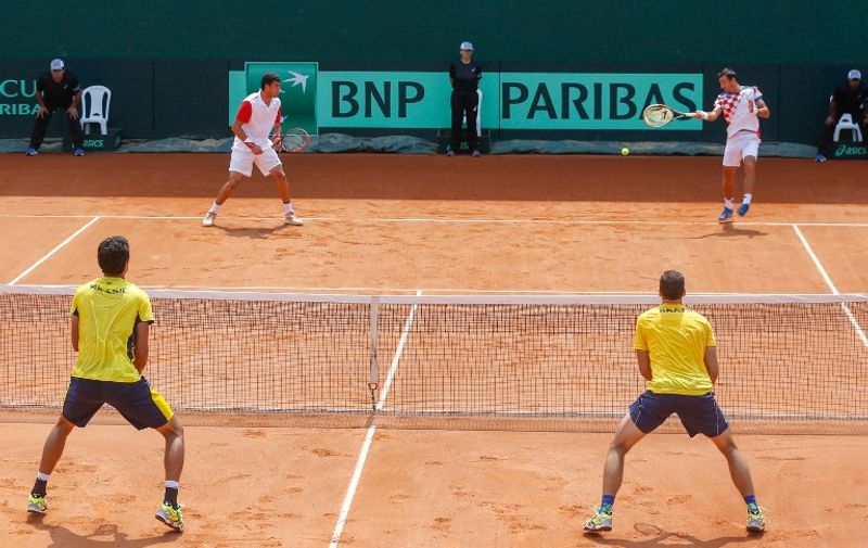 Brazilians Marcelo Melo (bottom, L) and Bruno Soares play against Croatian Ivan Dodig and Franko Skugor (top, L) during a Davis Cup World Group play-off double tennis match, in Florianopolis, Brazil, on September 19, 2015.  AFP PHOTO / THIAGO PEDRO