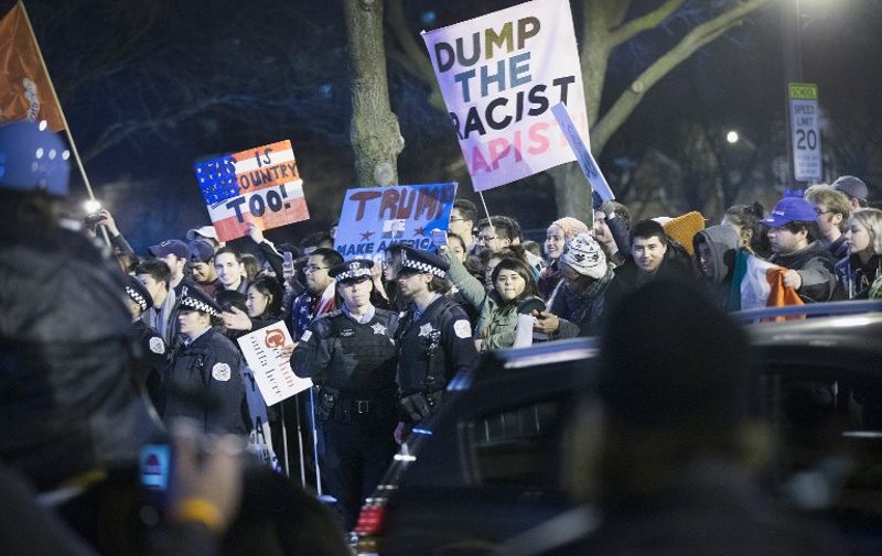 CHICAGO, IL - MARCH 11: Demonstrators taunt supporters of Republican presidential candidate Donald Trump as they leave a rally at the University of Illinois at Chicago which was postponed on March 11, 2016 in Chicago, Illinois. Organizers postponed the rally citing safety reasons after hundreds of demonstrators were ticketed for the event.   Scott Olson/Getty Images/AFP