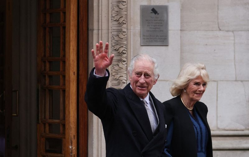 Britain's King Charles III (L) waves as he leaves, with Britain's Queen Camilla,  the London Clinic, in London, on January 29, 2024. Britain's King Charles III, 75, stayed the London Clinic following prostate surgery on January 26, 2024. (Photo by Adrian DENNIS / AFP)