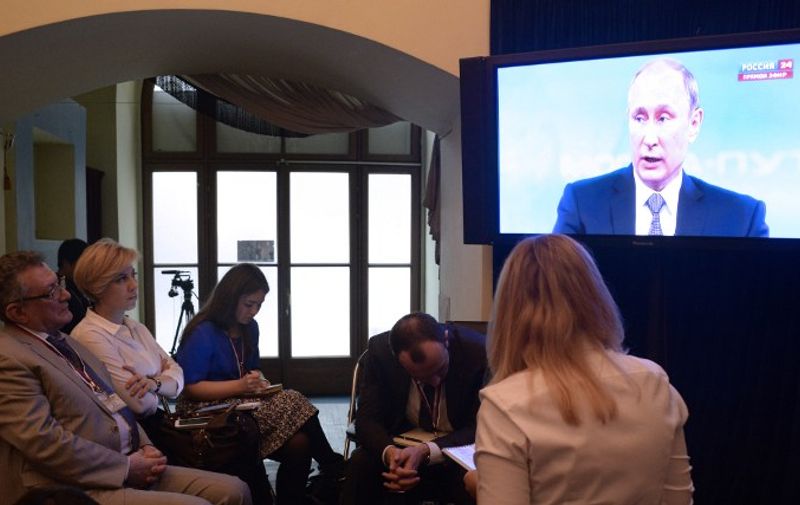 Journalists gather at a media centre as they watch a TV broadcast of Russian President Vladimir Putin&#8217;s annual televised phone-in with the nation in Moscow on April 16, 2015. AFP PHOTO / ALEXANDER NEMENOV