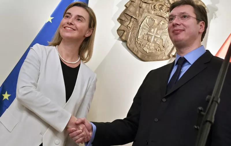 European Union foreign policy chief Federica Mogherini (L) shakes hands with Serbia's Prime Minister Aleksandar Vucic after their joint press conference in Belgrade on March 27, 2015.  AFP PHOTO / ANDREJ ISAKOVIC / AFP / ANDREJ ISAKOVIC