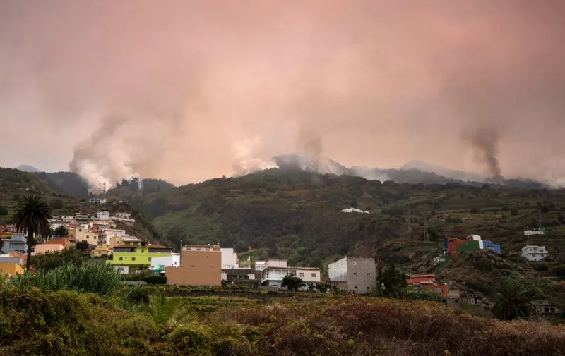 A wildfire rages out of control through forested slopes in La Matanza on the Canary island of Tenerife on August 19, 2023. More than 26,000 people may have been forced to flee a vast wildfire raging out of control in the Spanish holiday island of Tenerife, the emergency services said today. The huge blaze, which broke out late Tuesday in a mountainous northeastern area of the island, is the "most complex fire" to hit Spain's Atlantic Canary Islands in more than 40 years, the authorities say. (Photo by DESIREE MARTIN / AFP)