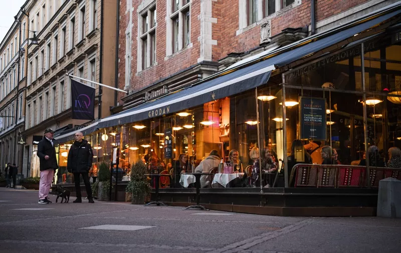 People dine in a restaurant on March 27, 2020 in Stockholm during the the new coronavirus COVID-19 pamdemic. - Sweden, which has stayed open for business with a softer approach to curbing the COVID-19 spread than most of Europe, on Friday limited gatherings to 50 people, down from 500. (Photo by Jonathan NACKSTRAND / AFP)