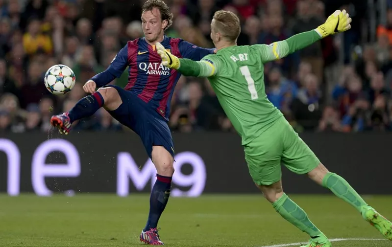 Barcelona's Croatian midfielder Ivan Rakitic (L) scores against Manchester City's goalkeeper Joe Hart (R) during the UEFA Champions League round of 16 football match FC Barcelona vs Manchester City at the Camp Nou stadium in Barcelona on March 18, 2015. AFP PHOTO/ 