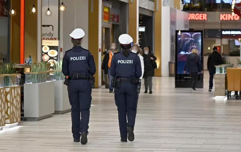 Austrian police officers patrol during a control in a shopping mall in Voesendorf, district Moedling, Austria, on November 16, 2021, during the ongoing coronavirus (Covid-19) pandemic. - Austrian Chancellor Schallenberg told AFP that the "difficult" lockdown imposed on November 15 on unvaccinated people had led to increased coronavirus vaccination rates. On November 15, Austria became the first EU country to lockdown the unvaccinated in a bid to halt spiralling virus infection rates of around 12,000 per day in the country of 8.9 million. (Photo by HANS PUNZ / APA / AFP) / Austria OUT